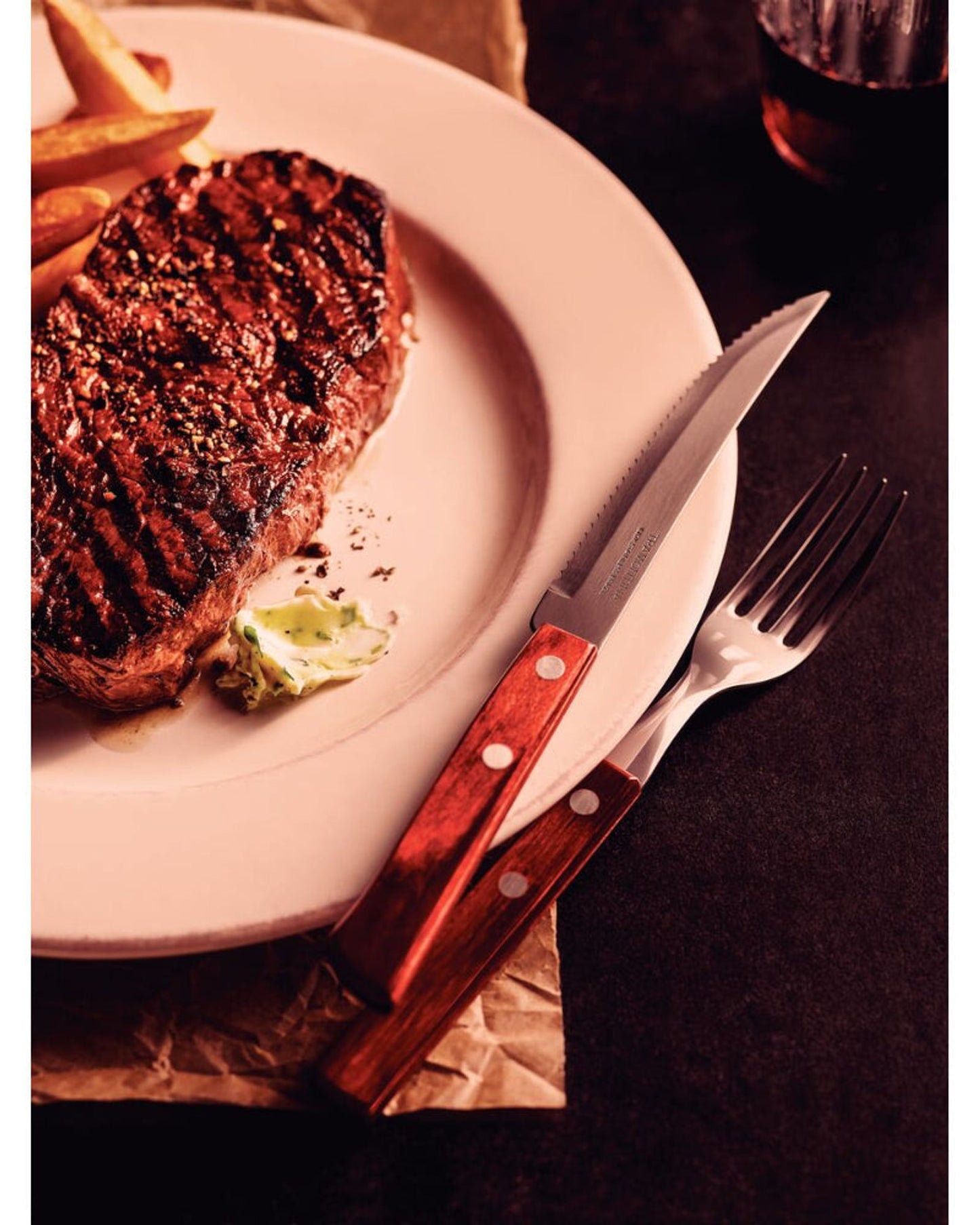 طقم سكاكين شرائح اللحم من ترامونتينا مكون من 6 قطع بشفرات من الفولاذ المقاوم للصدأ ومقابض خشبية معالجة باللون الأحمر.